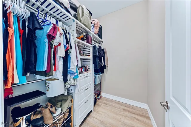 a view of walk in closet with clothes