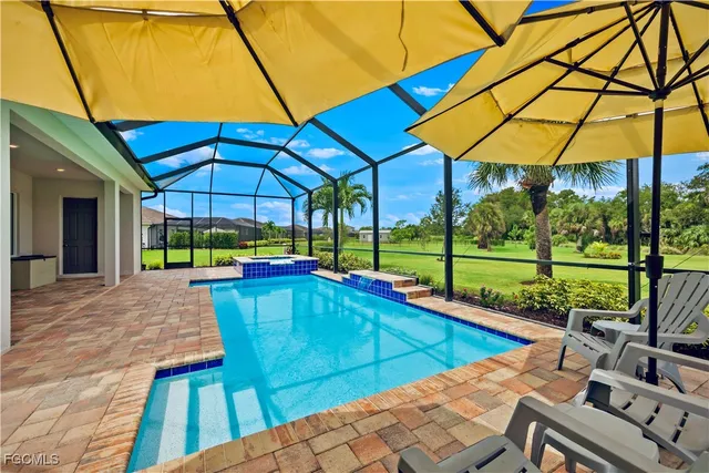 a view of a backyard with table and chairs under an umbrella