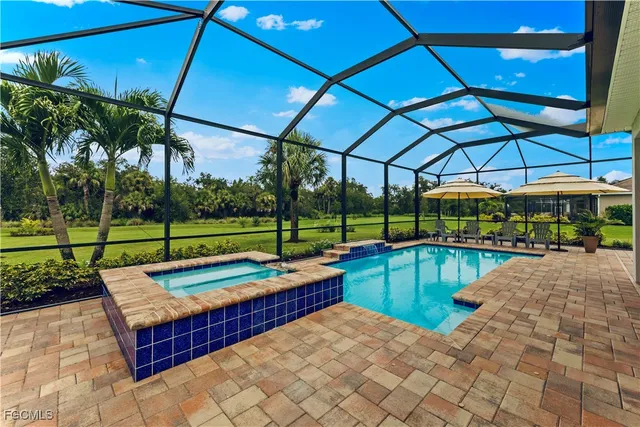 a view of a backyard with swimming pool and sitting area