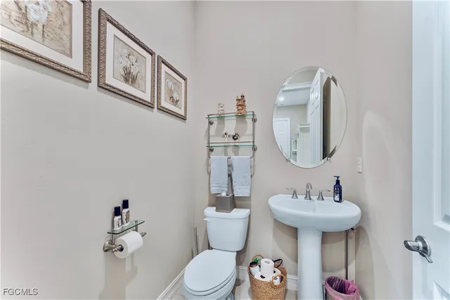 a bathroom with a toilet a sink and a mirror