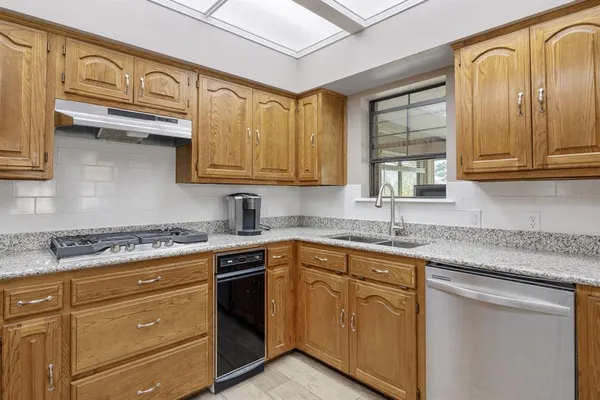 a kitchen with stainless steel appliances granite countertop a sink stove and cabinets