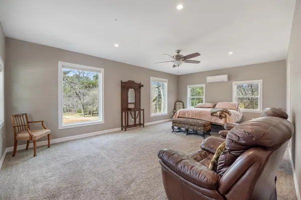 a spacious bedroom with a bed a couch and a window
