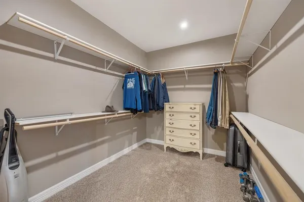 a view of walk in closet with clothes