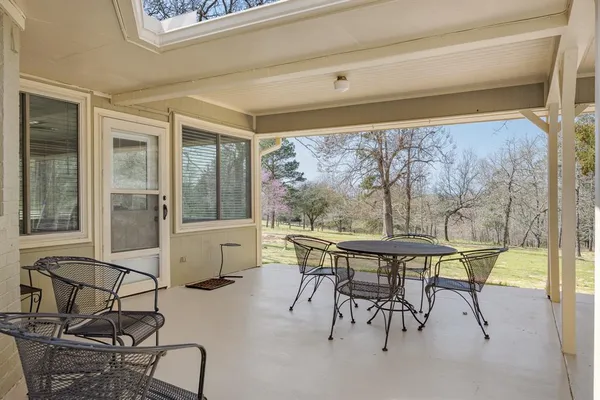a table and chairs in a room next to a window