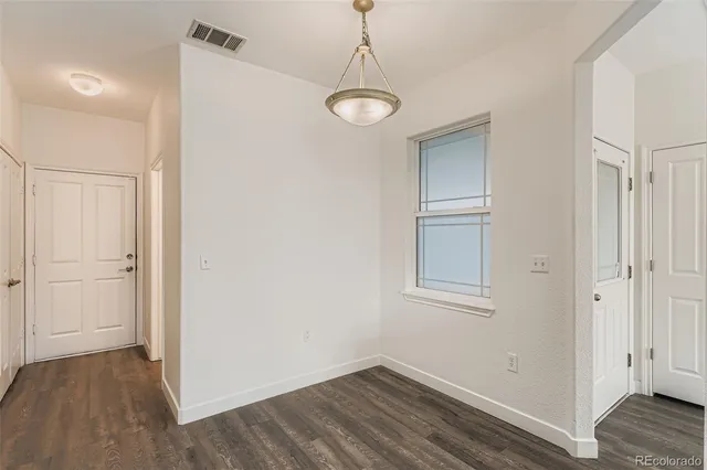 a view of a room with wooden floor and entryway