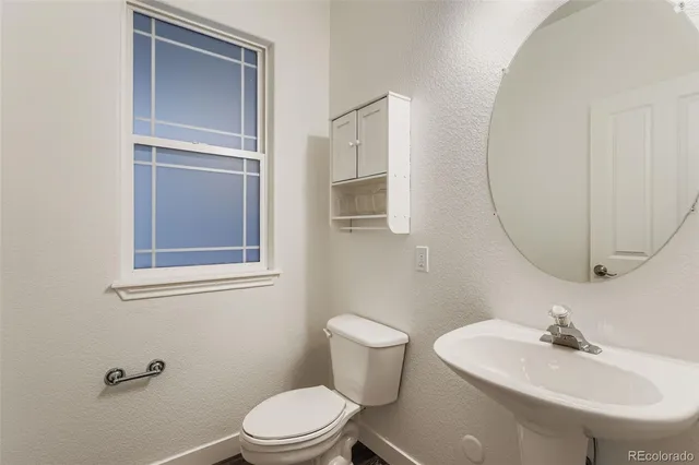 a bathroom with a sink toilet and a mirror