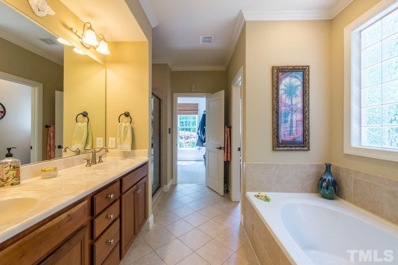 9512 Ray Road Raleigh, NC 27613 - Photo 11 of 25 a spacious bathroom with a granite countertop tub sink and mirror