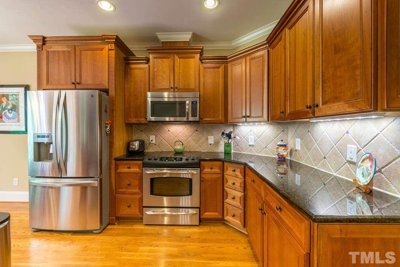 9512 Ray Road Raleigh, NC 27613 - Photo 8 of 25 a kitchen with stainless steel appliances granite countertop a refrigerator sink and stove