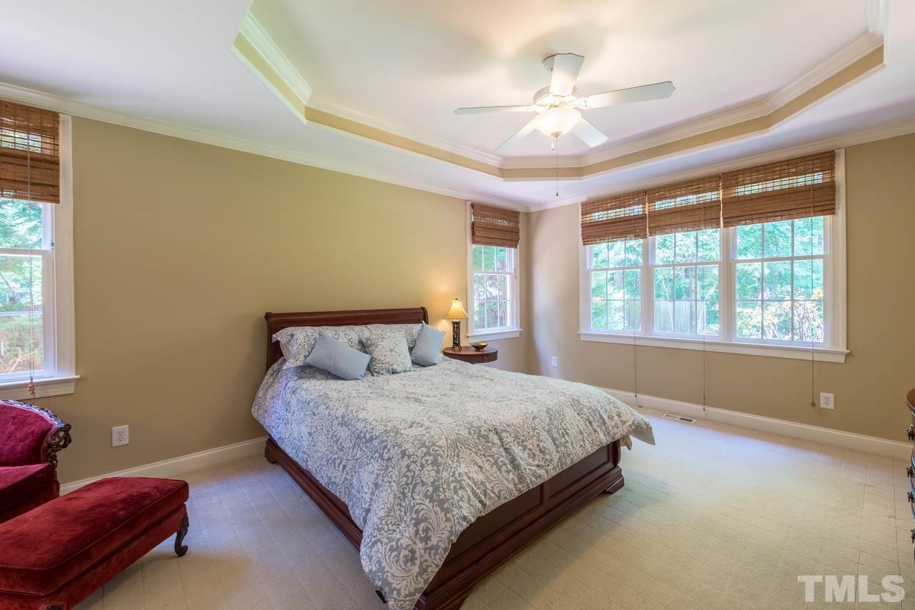 9512 Ray Road Raleigh, NC 27613 - Photo 10 of 25 a bedroom with a bed and a chandelier