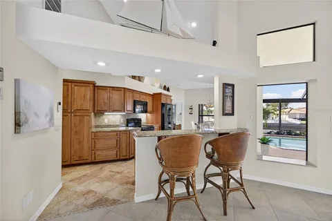 a kitchen with a table chairs refrigerator and cabinets
