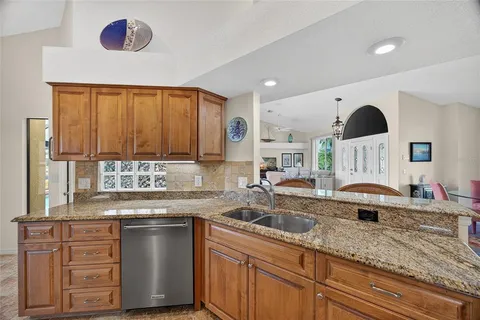 a kitchen with granite countertop a sink stainless steel appliances and cabinets