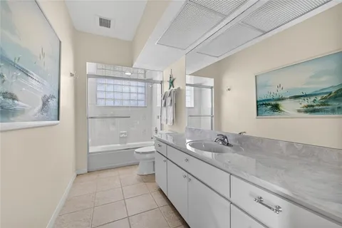 a bedroom with a bed a chandelier and a window