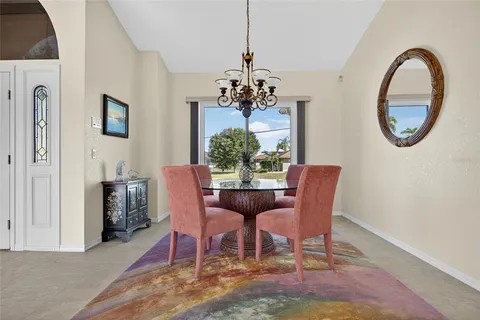 a dining room with furniture a rug and a chandelier