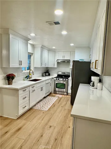 a kitchen with white cabinets and white appliances