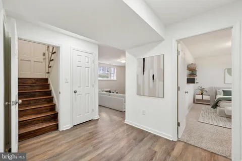 a view of a livingroom with wooden floor and kitchen space
