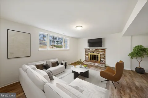 a living room with furniture a flat screen tv and a potted plant