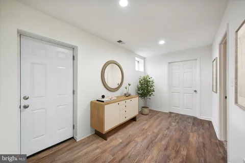a room with wooden floor and white wooden cabinets