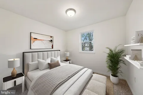 a bedroom with a large bed and a potted plant