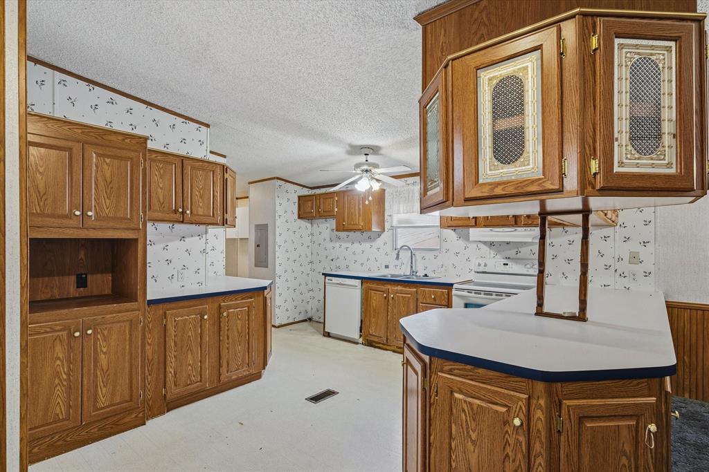 220 North Houston Street Edgewood, TX 75117 - Photo 12 of 30 a kitchen with a stove a sink and a refrigerator