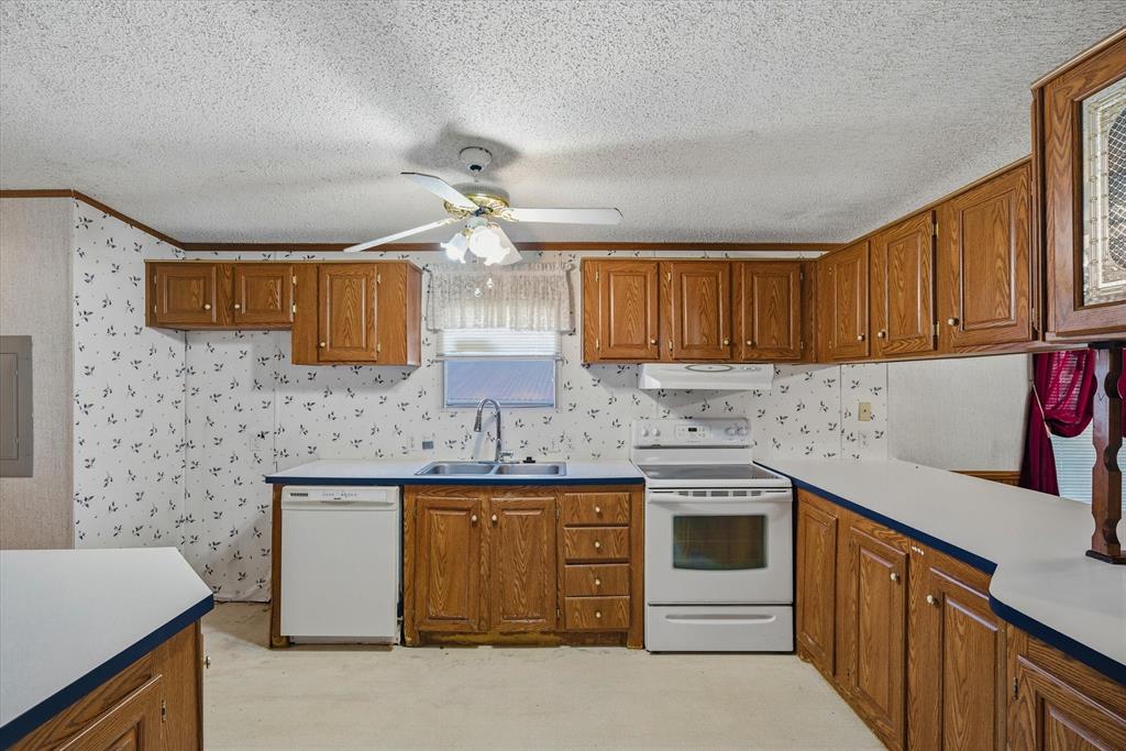 220 North Houston Street Edgewood, TX 75117 - Photo 13 of 30 a kitchen with stainless steel appliances granite countertop a sink stove and cabinets