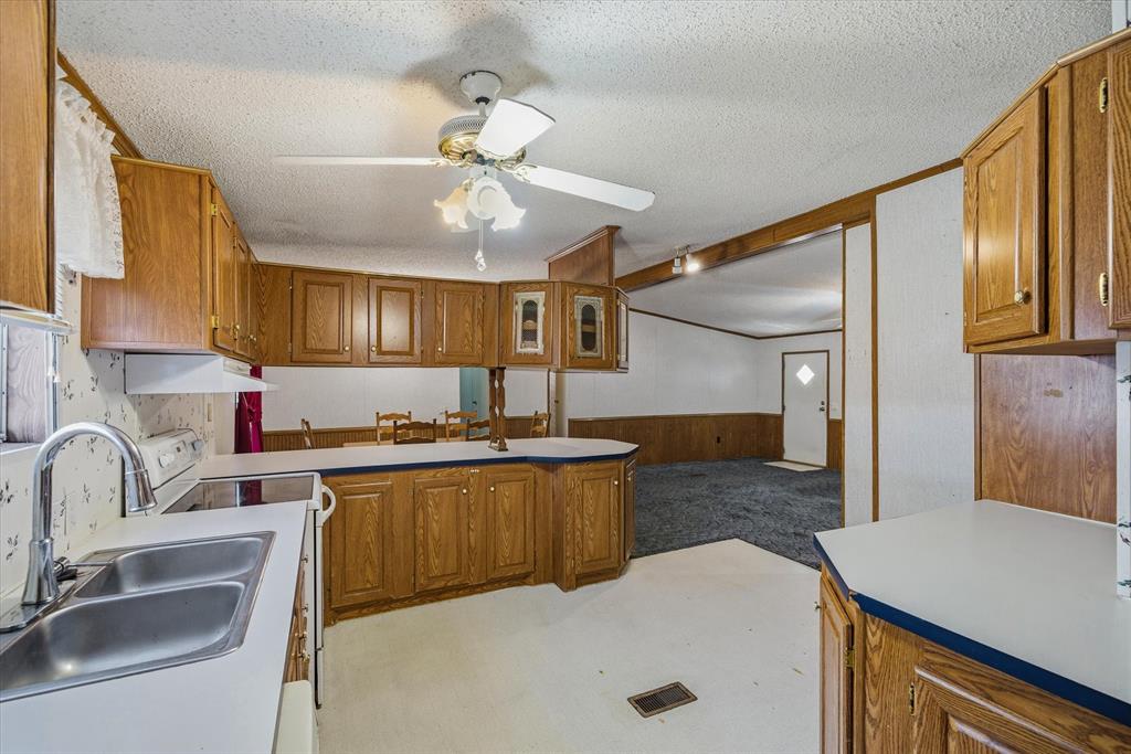 220 North Houston Street Edgewood, TX 75117 - Photo 16 of 30 a kitchen with a sink a stove and cabinets