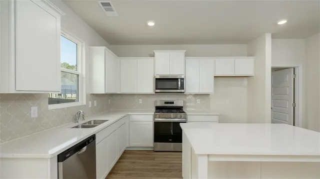 a kitchen with a sink a stove and cabinets