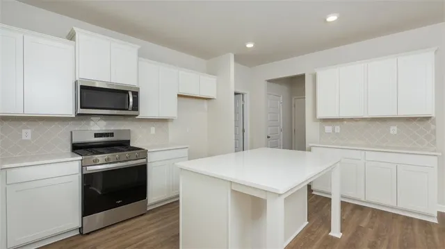 a kitchen with a stove a sink and a refrigerator