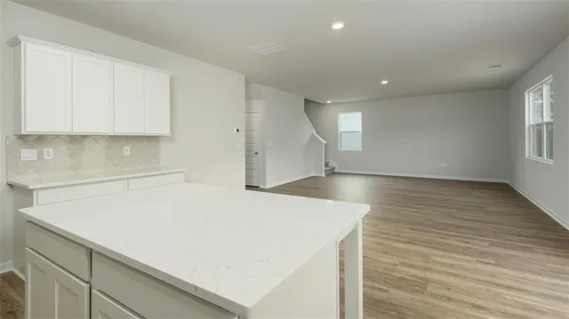 an empty room with wooden floor and window