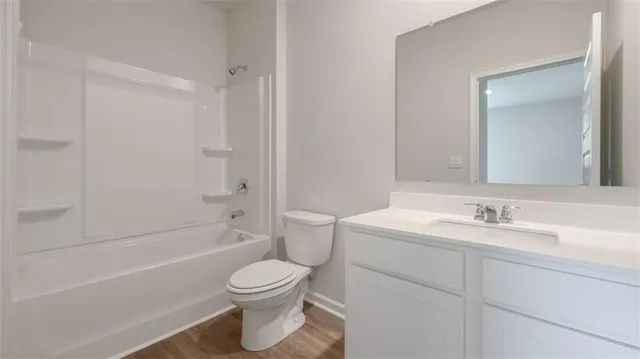a bathroom with a toilet sink vanity tub and shower