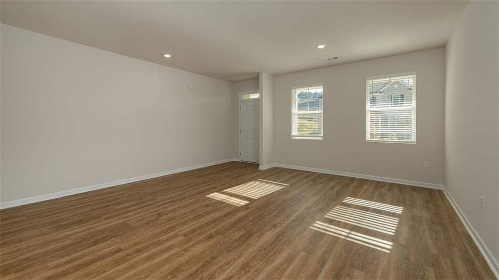1949 Van Alen Court Dacula, GA 30019 - Photo 6 of 46 an empty room with wooden floor and windows