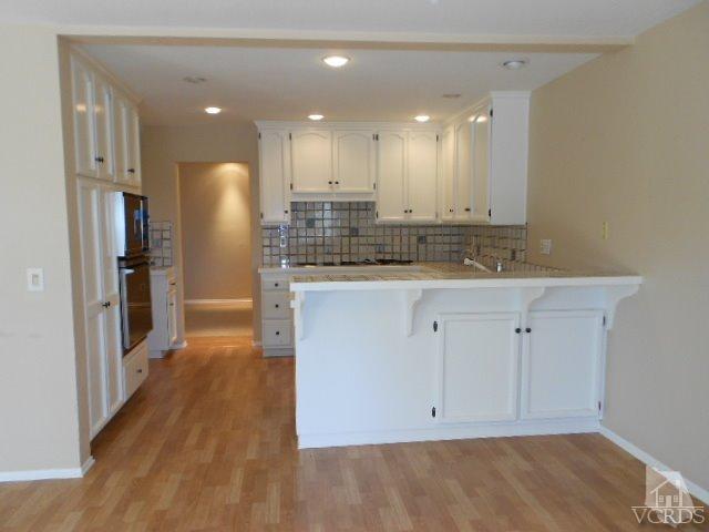 2201 Vina Del Mar Oxnard, CA 93035 - Photo 18 of 48 a view of a kitchen with center island wooden floor and a sink