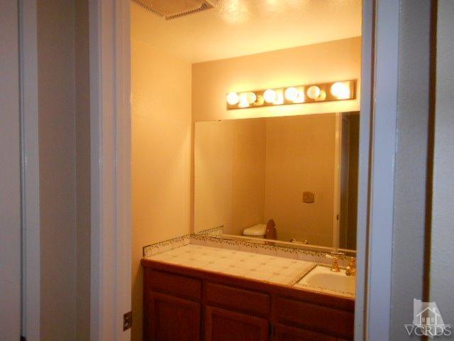 2201 Vina Del Mar Oxnard, CA 93035 - Photo 23 of 48 a bathroom with a granite countertop sink and a mirror