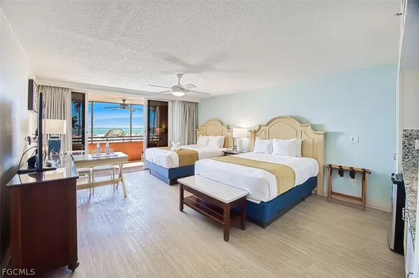 a bedroom with two beds and lamps