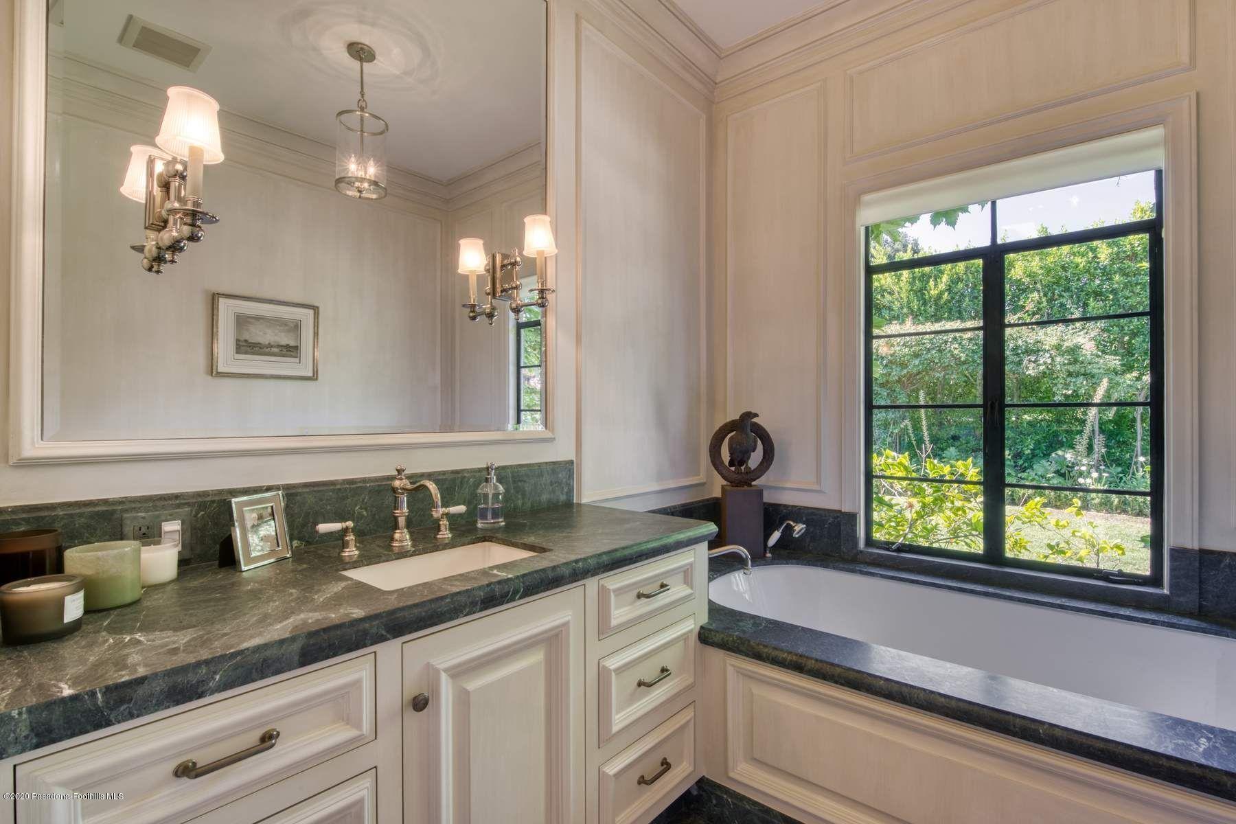 400 South San Rafael Avenue Pasadena, CA 91105 - Photo 25 of 49 a bathroom with a granite countertop sink a large mirror a and a window