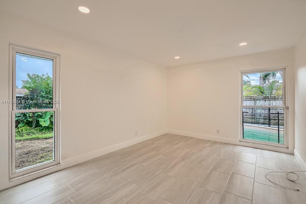 115 West Mango Road Lake Worth, FL 33467 - Photo 13 of 32 a view of an empty room with wooden floor and a window