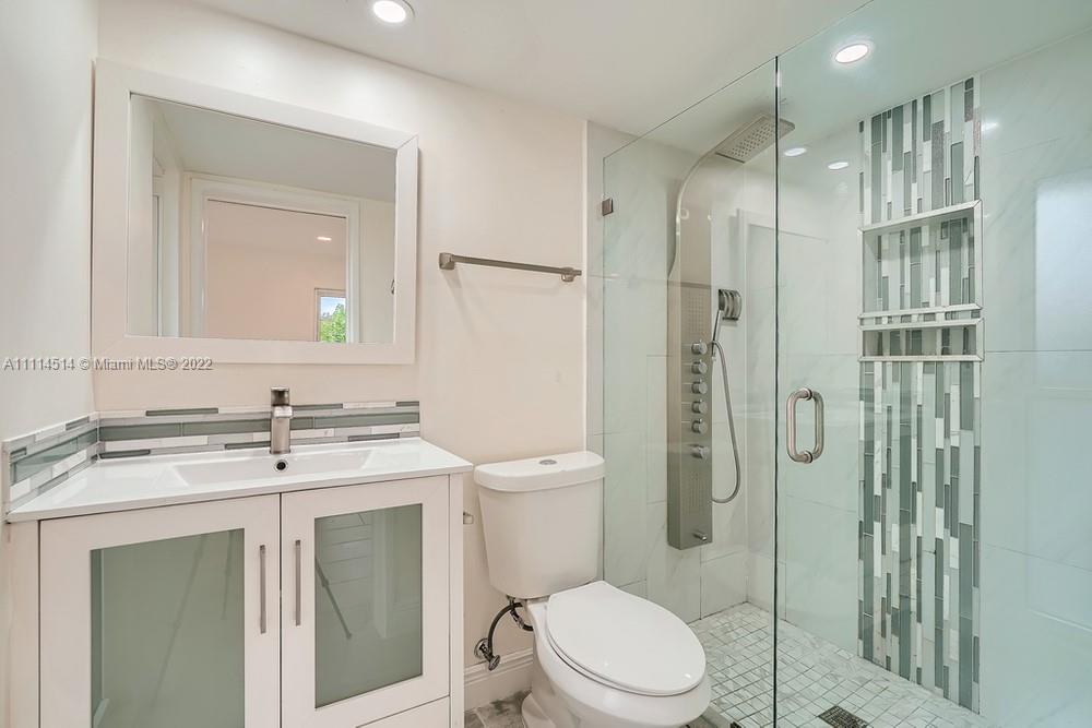 115 West Mango Road Lake Worth, FL 33467 - Photo 17 of 32 a bathroom with a sink a toilet and shower