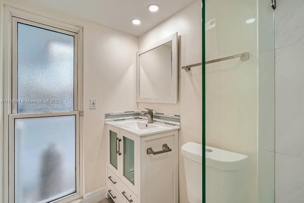 115 West Mango Road Lake Worth, FL 33467 - Photo 18 of 32 a bathroom with a sink and mirror with toilet