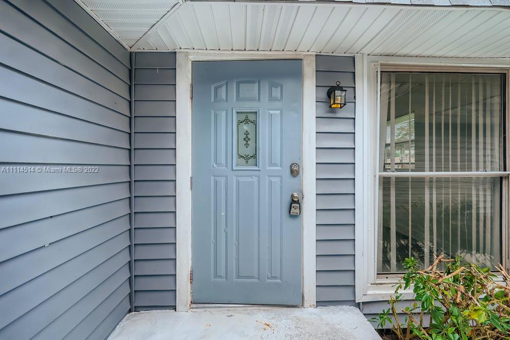 115 West Mango Road Lake Worth, FL 33467 - Photo 3 of 32 a view of front door and potted plants