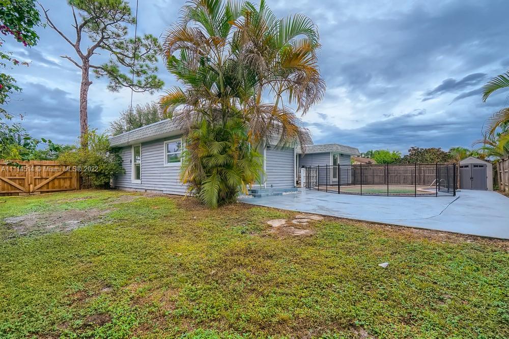 115 West Mango Road Lake Worth, FL 33467 - Photo 31 of 32 a palm tree sitting in front of a house with a yard
