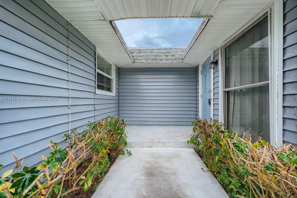 115 West Mango Road Lake Worth, FL 33467 - Photo 32 of 32 a side view of a house with a yard and flowers