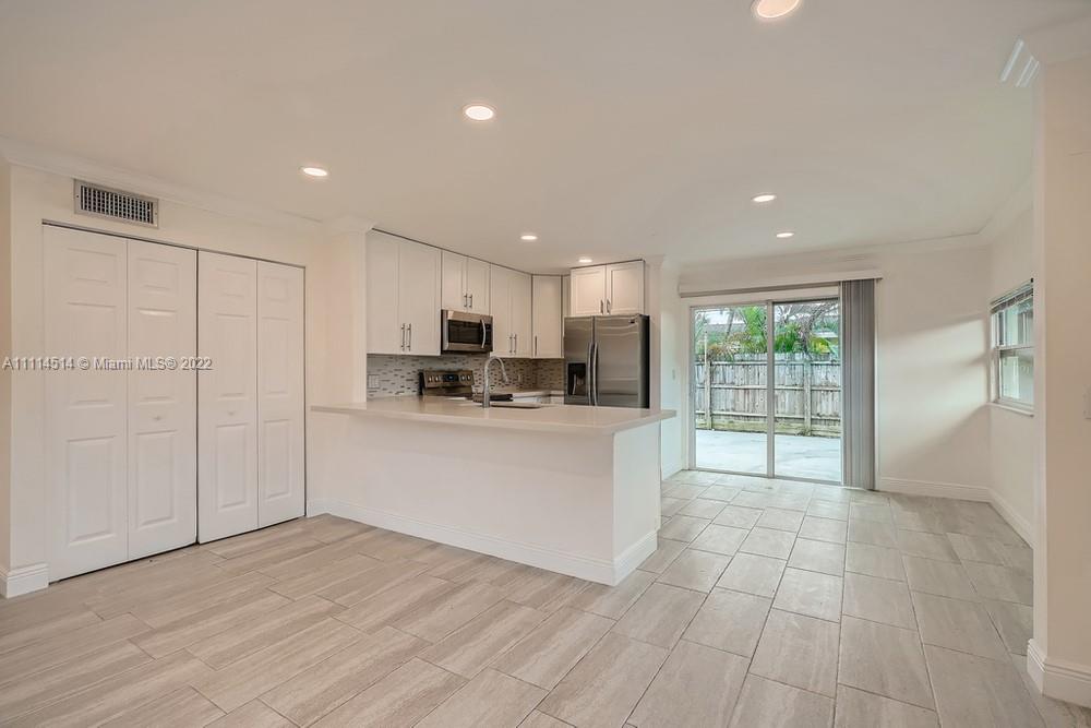 115 West Mango Road Lake Worth, FL 33467 - Photo 7 of 32 a kitchen with stainless steel appliances granite countertop a refrigerator sink and cabinets