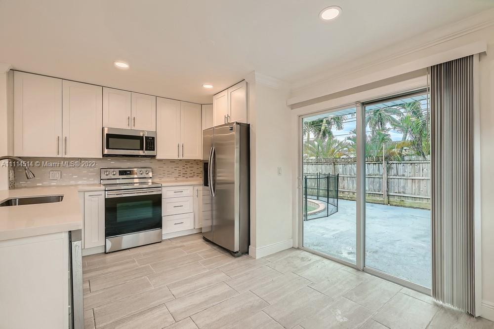 115 West Mango Road Lake Worth, FL 33467 - Photo 9 of 32 a kitchen with a stove a refrigerator and a sink
