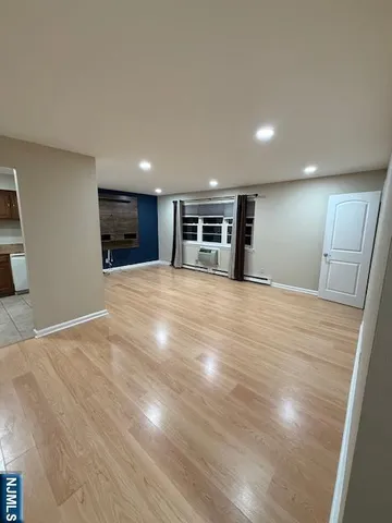 a view of an empty room with wooden floor