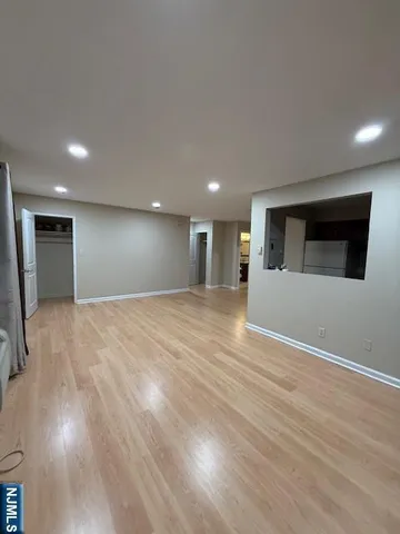 a view of empty room with wooden floor