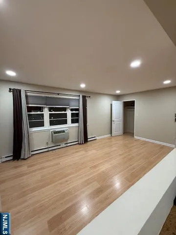 a view of empty room with wooden floor and windows