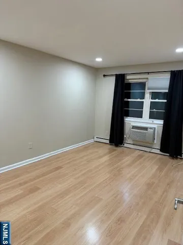a view of empty room with wooden floor and stove