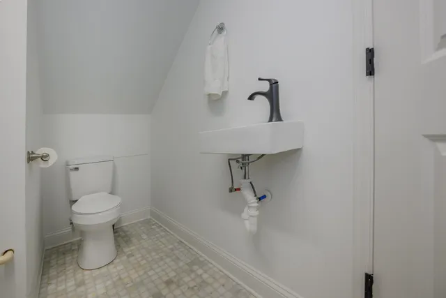 a bathroom with a toilet sink and a mirror