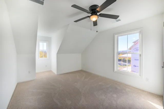 en empty room with windows and ceiling fan