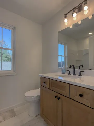a bathroom with a toilet a sink and mirror