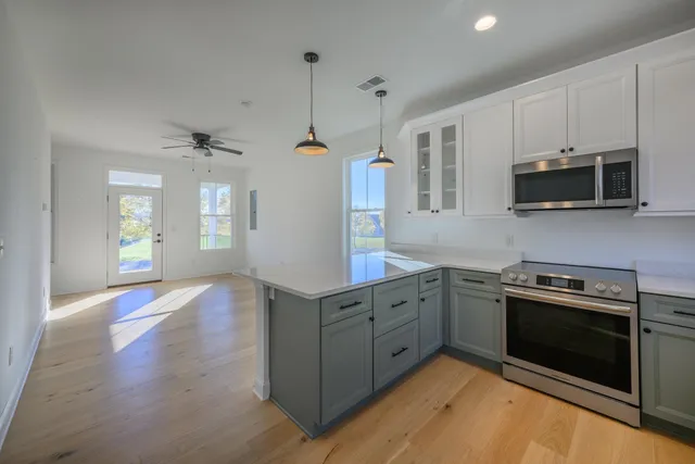 a kitchen with stainless steel appliances granite countertop a stove a sink and a microwave
